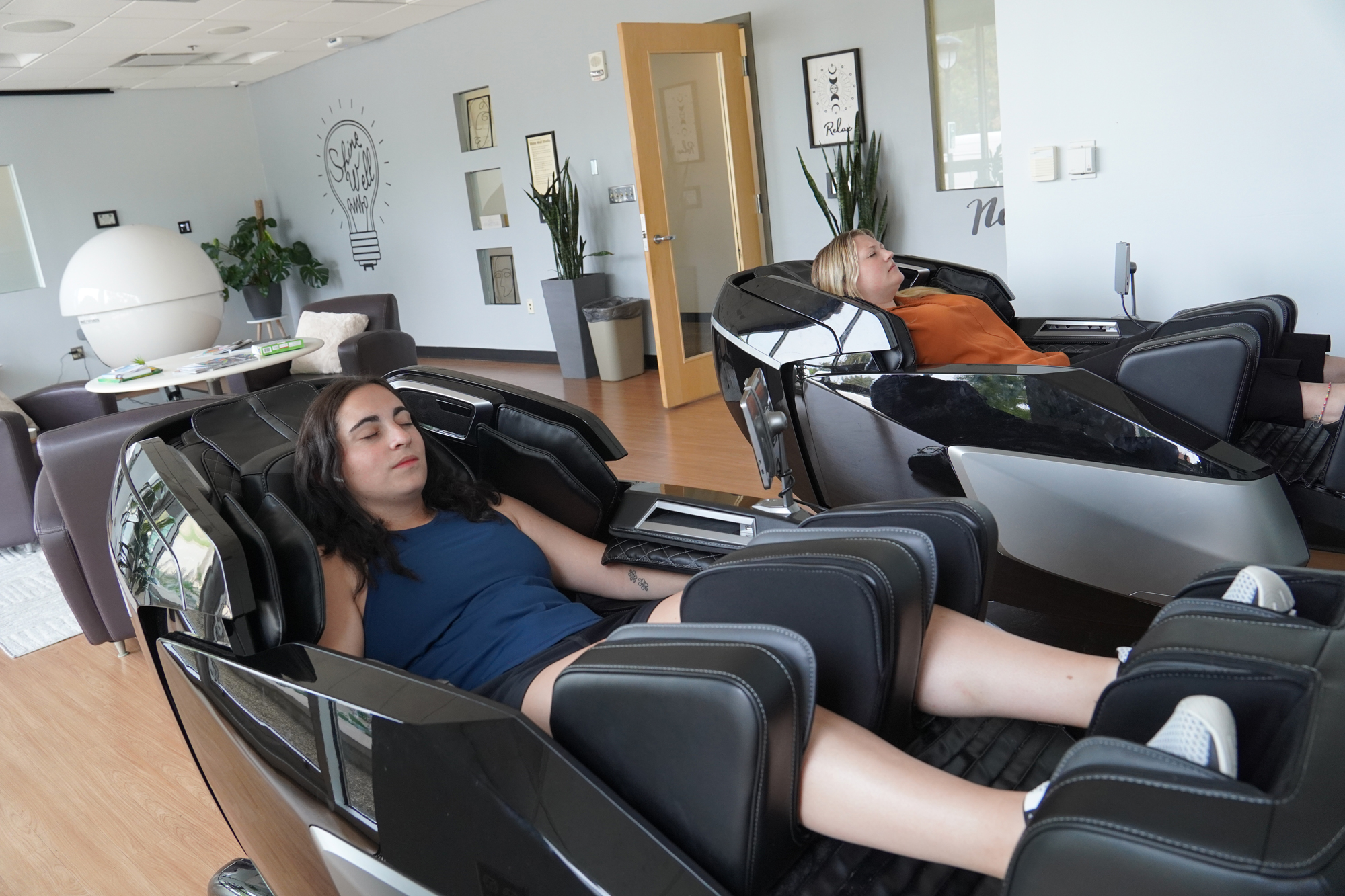 2 women in massage chairs in a wellness studio