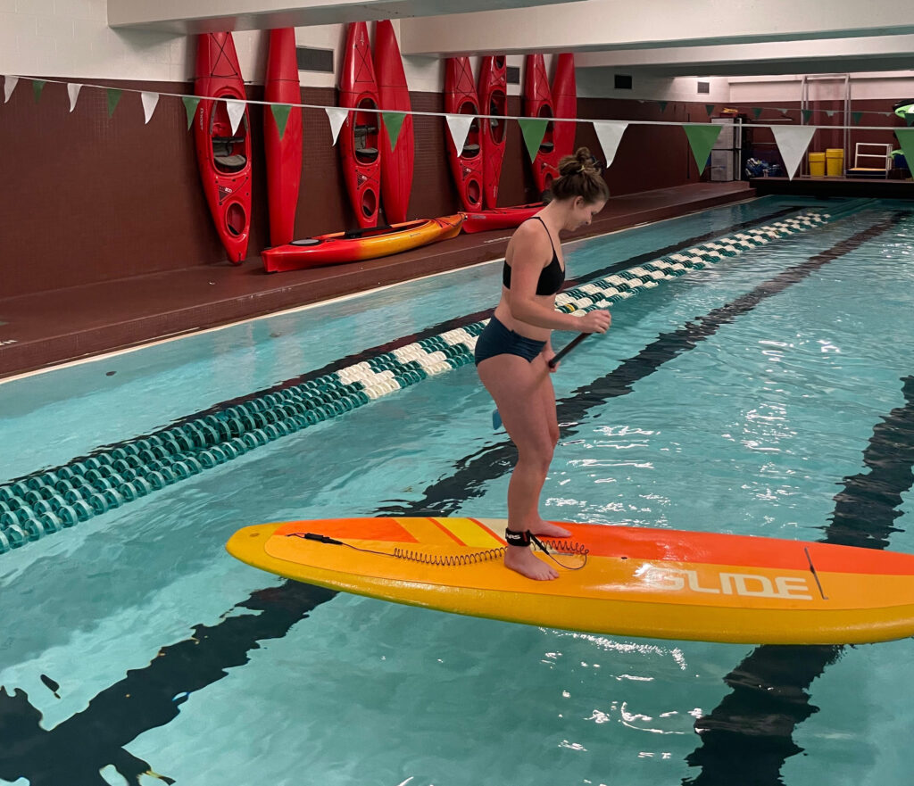 Woman standing on paddle board.